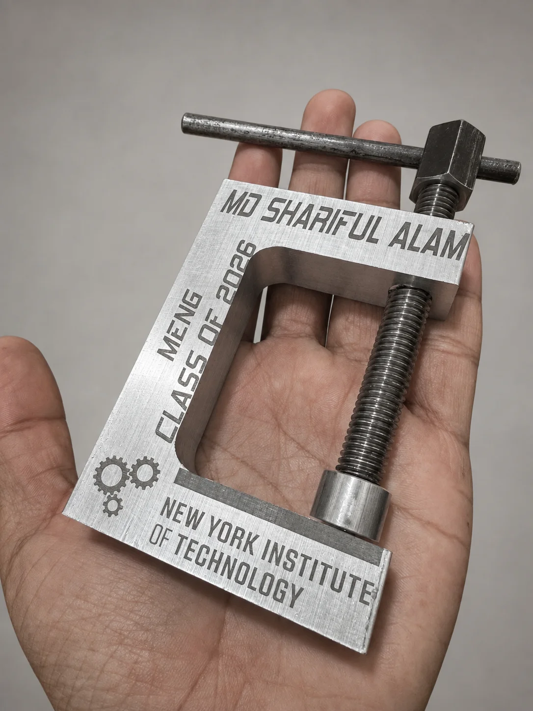 Completed machined and laser-engraved aluminum C-clamp held in hand